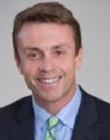 Steve Witt has short brown hair, wears a suit and tie, and smiles for the camera
