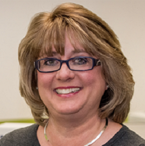 Cindy wears black glasses, has shoulder-length blonde hair, and smiles for the camera