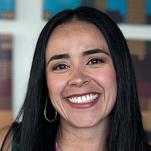 Natalia has long dark hair and smiles for the camera