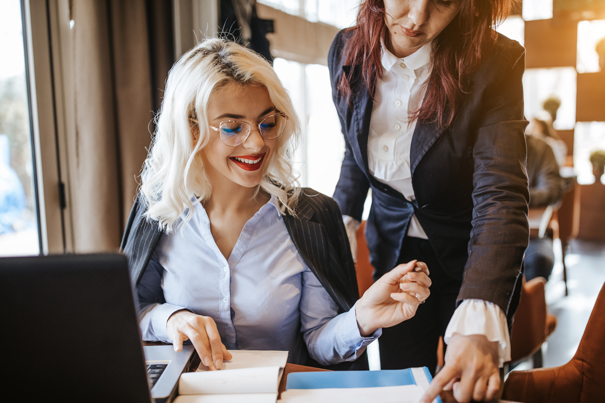 An employee reviews invoices with her manager