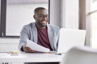 Man smiling while using laptop