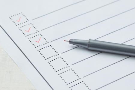 Image of a pen placed on top of a printed checklist
