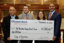 Brockton Leaders stand with Eastern Bank Foundation members holding a check marking the donation