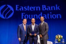 Deval Patrick holds his award and stands with Bob Rivers and Turahn Dorsey