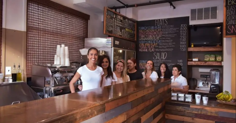 Toasted Flats employees smile for a picture behind the counter of their restaurant