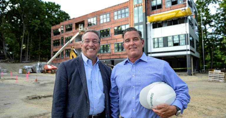 Heritage Companies president Michael Kiley stands outside of developing building with Eastern Bank commercial real estate director Nicholas Moise
