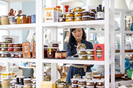 A woman takes inventory of her food goods in her store